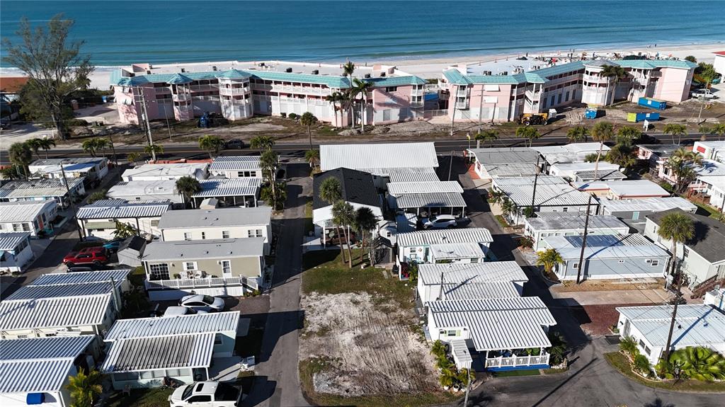 An aerial view shows a mobile home park with a vacant lot near the beach — 2601 GULF DRIVE N UNIT 310, BRADENTON BEACH, FL