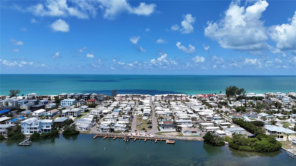 An aerial view shows a coastal community with mobile homes, houses, and a boat dock — 2601 GULF DRIVE N UNIT 310, BRADENTON BEACH, FL