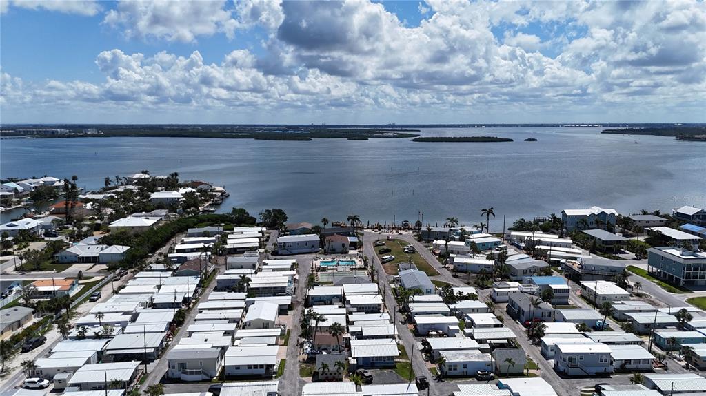 An aerial view shows a dense residential community of mobile homes situated along a bay — 2601 GULF DRIVE N UNIT 310, BRADENTON BEACH, FL