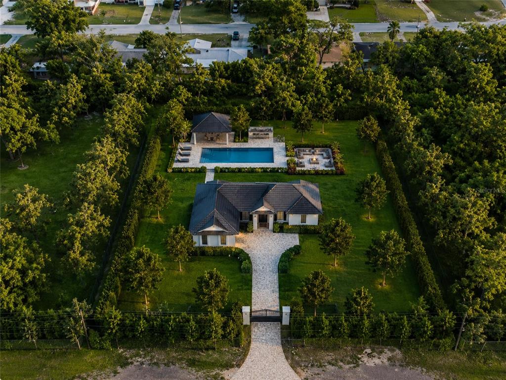 An aerial view shows a single-story house with a pool, patio, and gated driveway — 11496 74TH AVENUE, SEMINOLE, FL