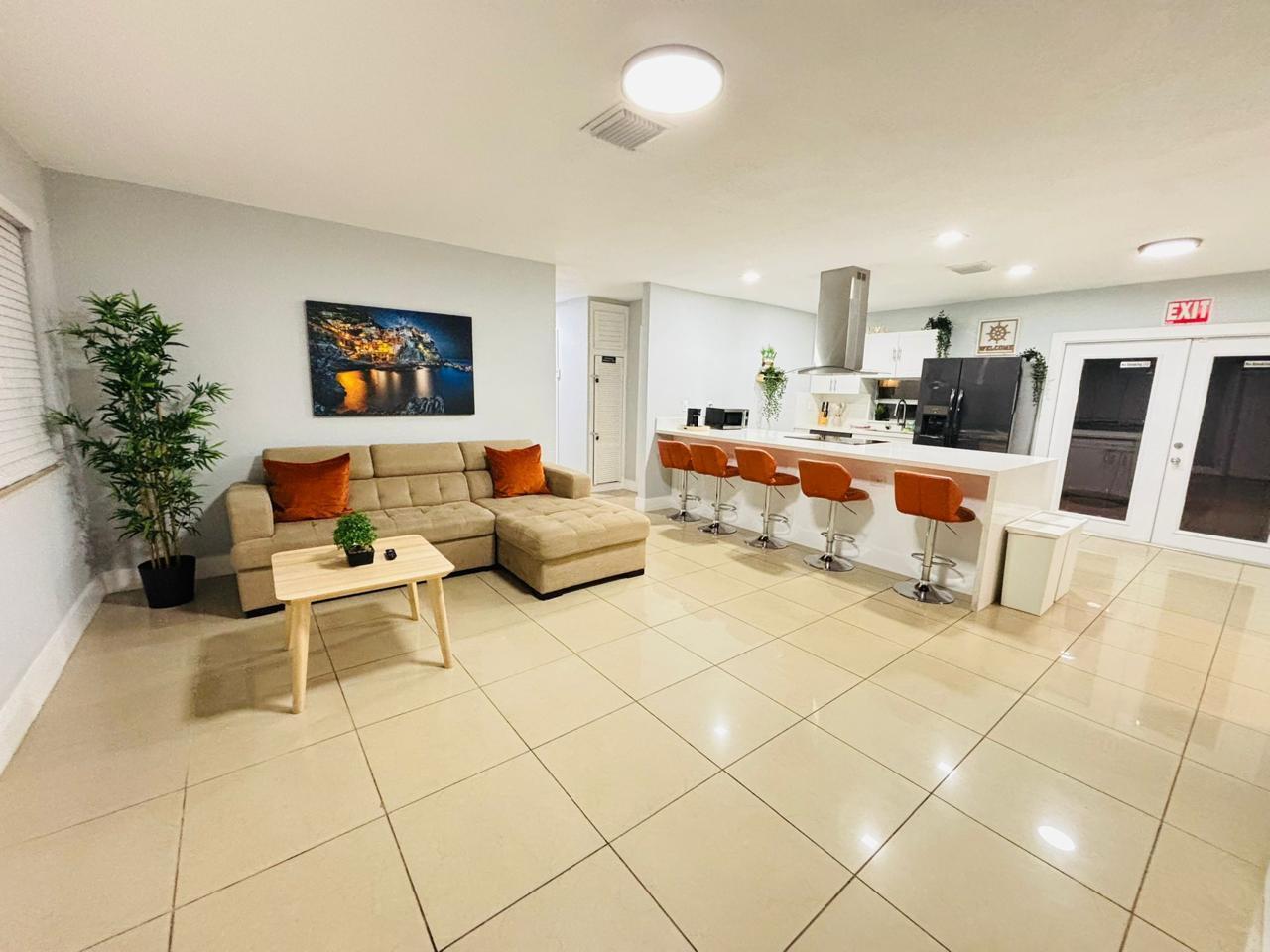 A living room with a beige sectional sofa and a kitchen with a breakfast bar — 2010 NE 1st Avenue, Pompano Beach FL 33060, POMPANO BEACH, FL