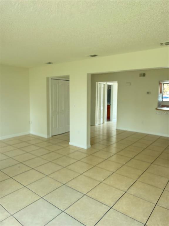 An interior view of a room with light-colored tile flooring and white walls — 1322 VERONA STREET, KISSIMMEE, FL