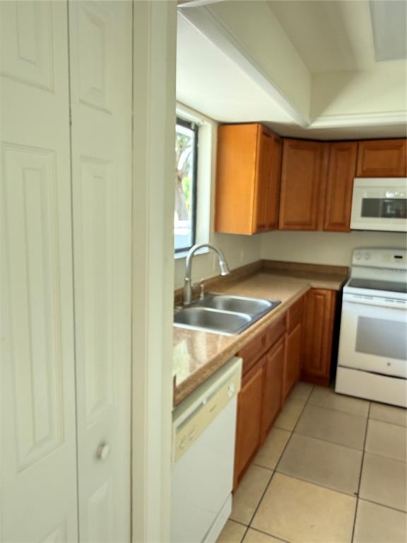 A kitchen features wood cabinets, a white stove, a dishwasher, and a double-basin sink — 1322 VERONA STREET, KISSIMMEE, FL