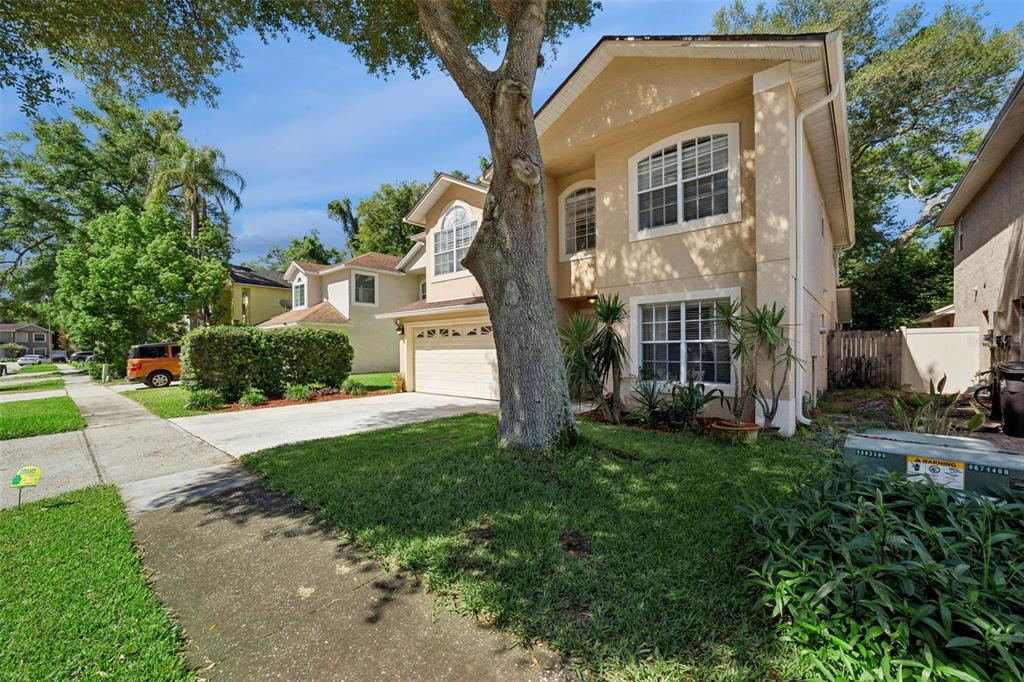 A two-story tan house with a garage, a large tree, and a concrete driveway — 436 OPAL COURT, ALTAMONTE SPRINGS, FL