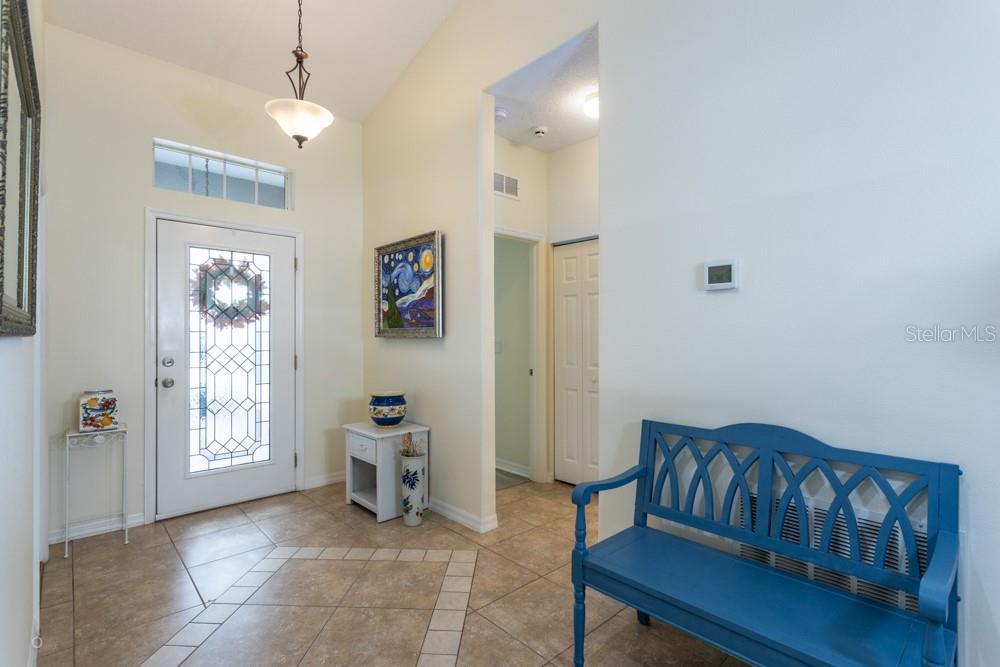 An entryway features tile flooring, a blue bench, a white front door, and a light fixture — 150 W WATERSIDE PARKWAY, PALM COAST, FL