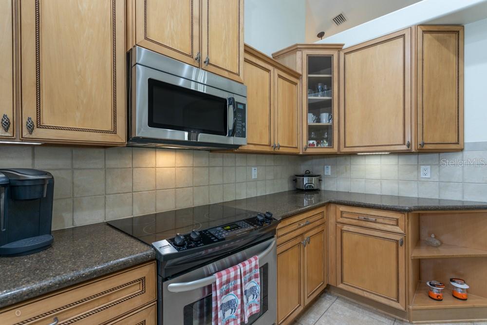 A kitchen features light wood cabinets, a stainless steel microwave, and a dark countertop — 150 W WATERSIDE PARKWAY, PALM COAST, FL