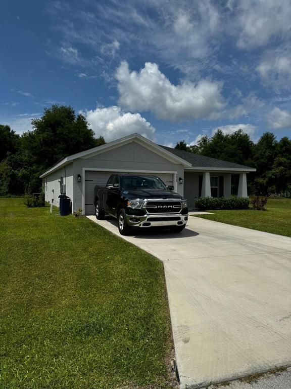 A single-story house with a concrete driveway and a black pickup truck parked in front — 9028 SE 41ST COURT ROAD, OCALA, FL