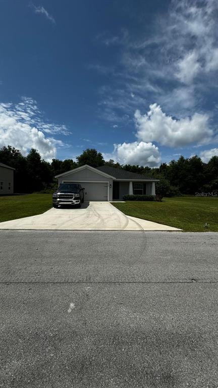 A single-story house with a gray exterior, a two-car garage, and a concrete driveway — 9028 SE 41ST COURT ROAD, OCALA, FL