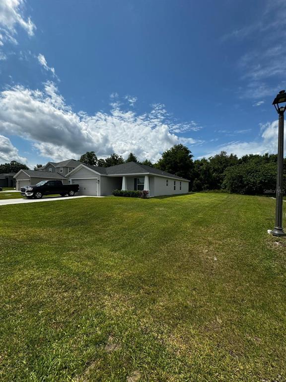 A single-story house with a gray roof and a black truck parked in the driveway — 9028 SE 41ST COURT ROAD, OCALA, FL