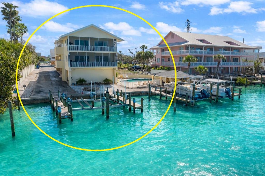 An elevated waterfront house with a screened balcony, private boat slips, and a swimming pool — 109 BAYSHORE ROAD UNIT 10, NOKOMIS, FL
