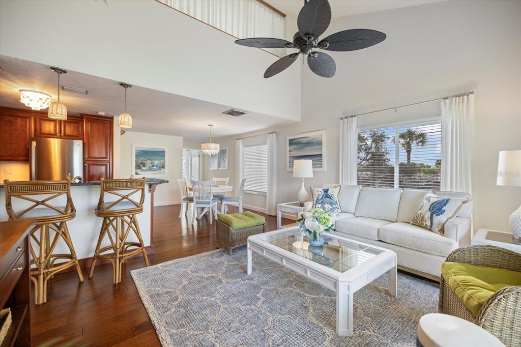 A living room and kitchen area with hardwood floors, a white sofa, and ceiling fan — 109 BAYSHORE ROAD UNIT 10, NOKOMIS, FL