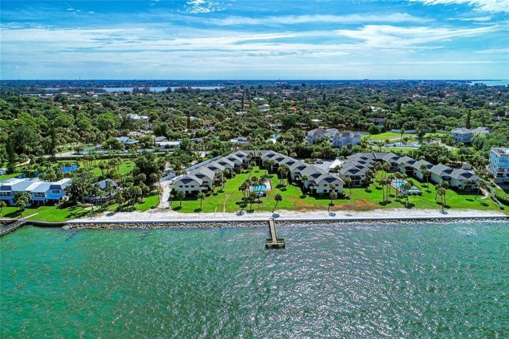 An aerial view of a waterfront condominium complex with a private pier and swimming pool — 4660 OCEAN BOULEVARD UNIT G1, SARASOTA, FL