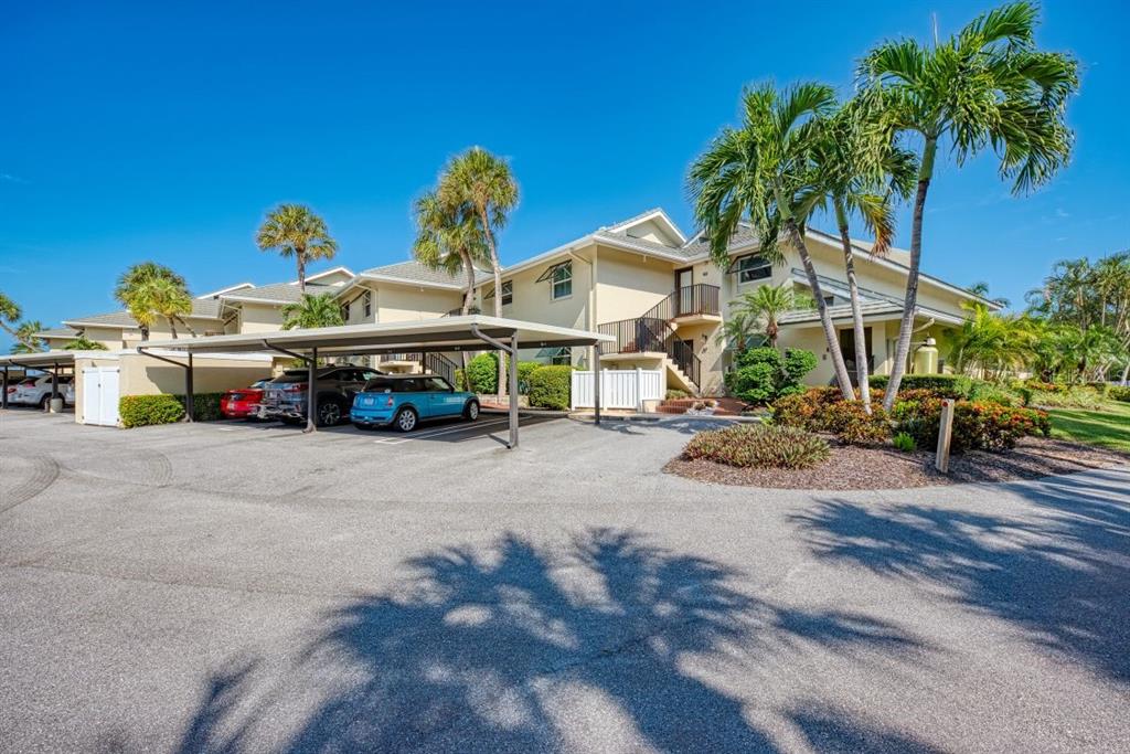 A multi-story apartment building with a covered parking area and palm trees in front — 4660 OCEAN BOULEVARD UNIT G1, SARASOTA, FL