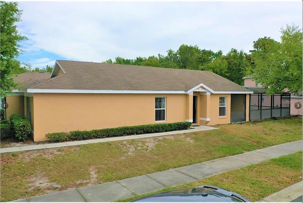 A single-story tan house with a brown shingled roof and a screened-in back porch — 108 SUNDOWN COURT, DAVENPORT, FL