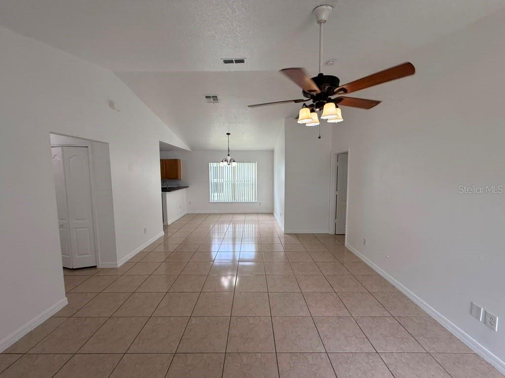 An open-concept living area features light-colored tile flooring, white walls, and a ceiling fan — 108 SUNDOWN COURT, DAVENPORT, FL