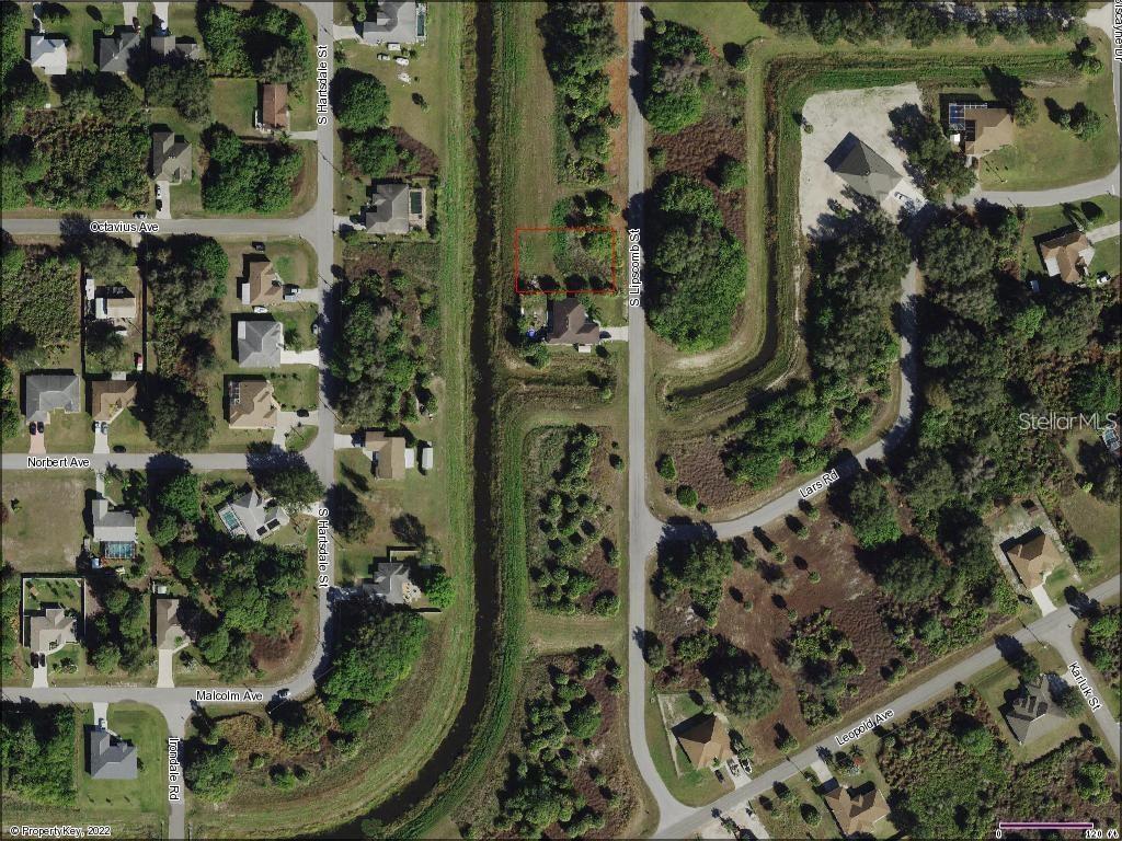 An aerial map shows a vacant, rectangular lot highlighted in red along a residential street — Lot 8 S LIPSCOMB STREET, NORTH PORT, FL