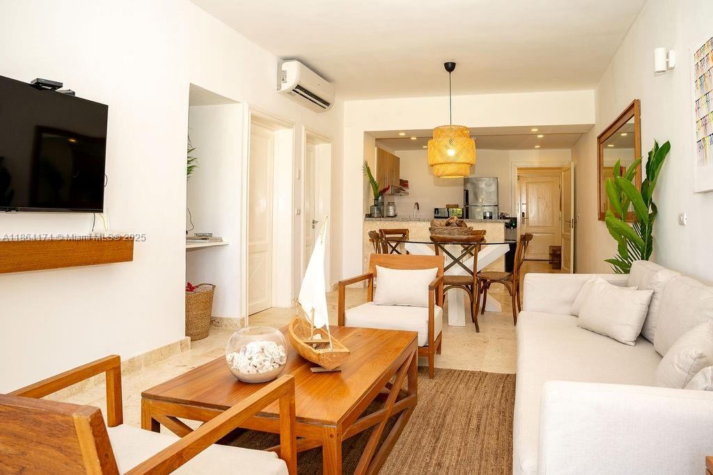 A living room and dining area feature light tile floors, white walls, and wooden furniture — 0000 8C3F+Q62, Las Terrenas 32000, Dominican Republic # 1, DR, DR