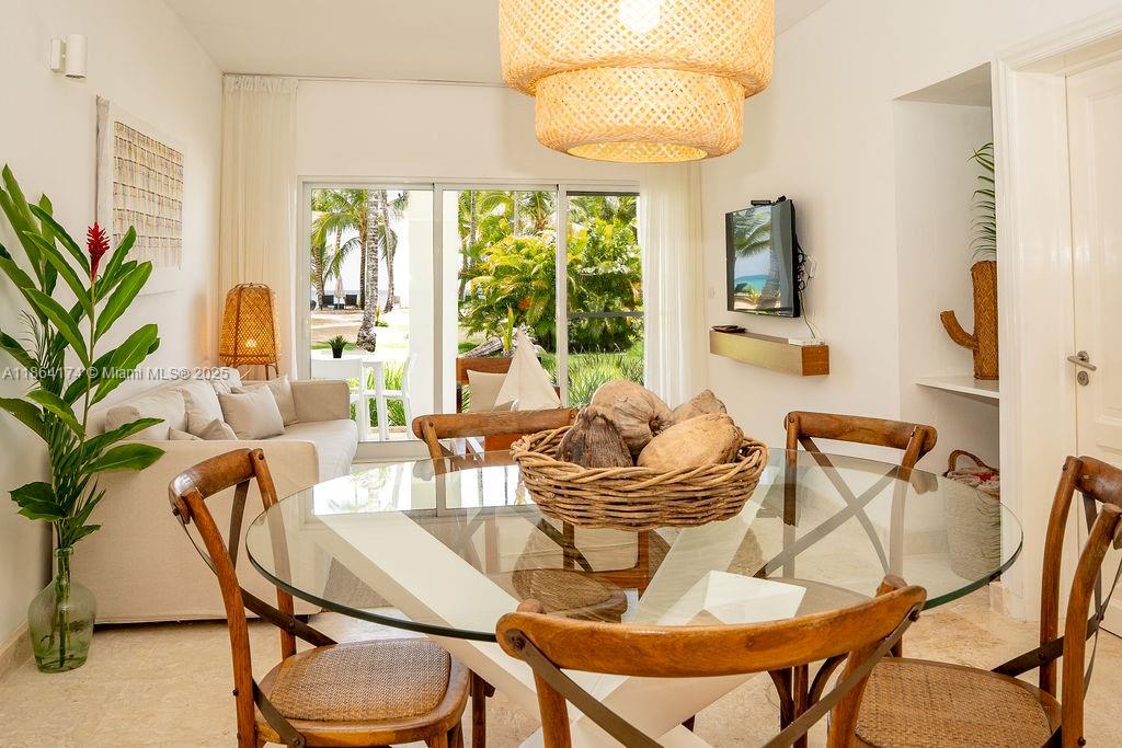 A dining area with a glass table and wooden chairs overlooks a tropical outdoor patio — 0000 8C3F+Q62, Las Terrenas 32000, Dominican Republic # 1, DR, DR