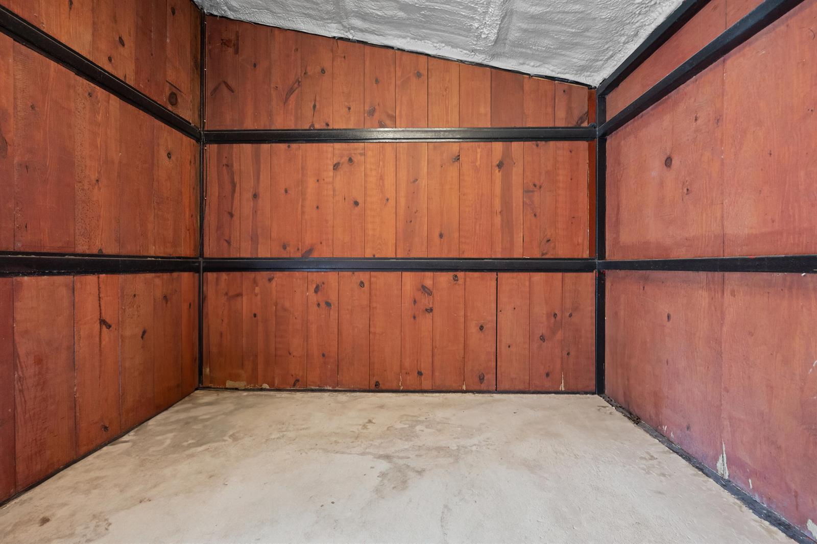 An empty room with wood-paneled walls, black metal trim, and a concrete floor — 3570 B Road, FL 33470, FL
