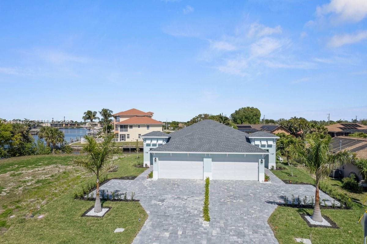 An aerial view of a duplex house with two garages and a paved driveway — 1107 SE 38 ST, Cape Coral FL 33904, CAPE CORAL, FL