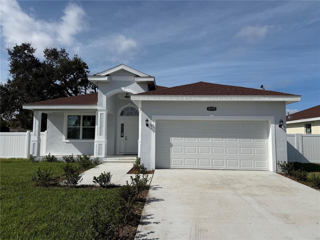 A single-story house with a white stucco exterior, a two-car garage, and a front walkway — 4205 57TH AVENUE N, ST PETERSBURG, FL