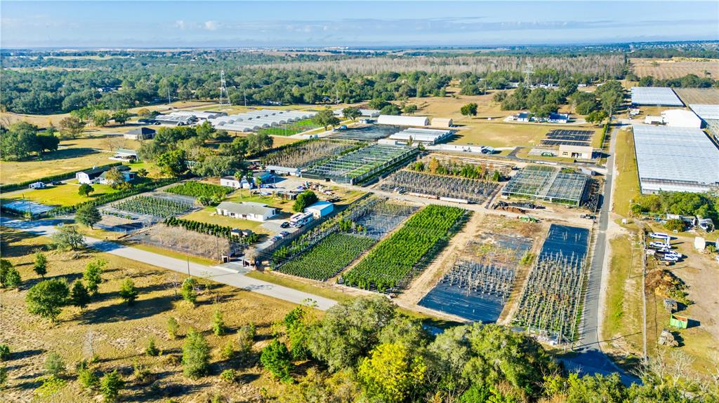 An aerial view shows a large plant nursery with multiple greenhouses and outdoor growing fields — 4004 REX DRIVE, WINTER GARDEN, FL