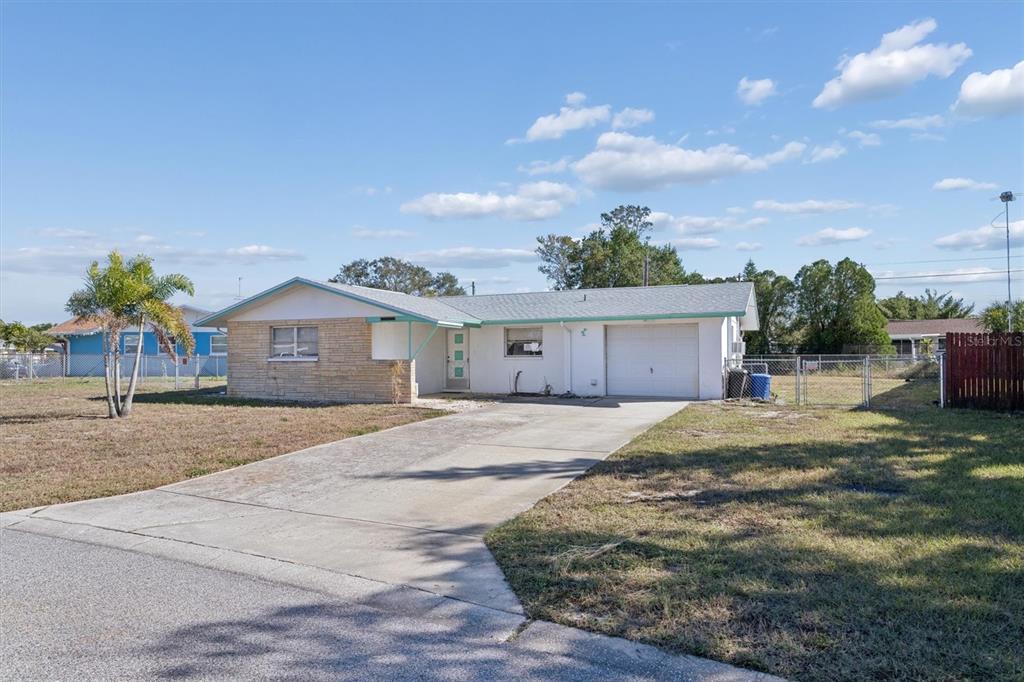 A single-story house with a stone facade, white stucco walls, and an attached garage — 7608 REDCOAT AVENUE, PORT RICHEY, FL