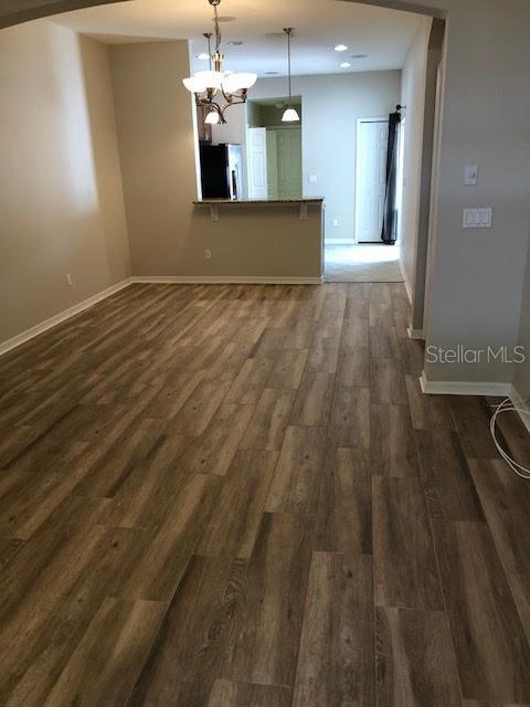 A living area with wood-look flooring leads to a kitchen with a breakfast bar — 6344 LAKE SMITH CIRCLE, WINDERMERE, FL