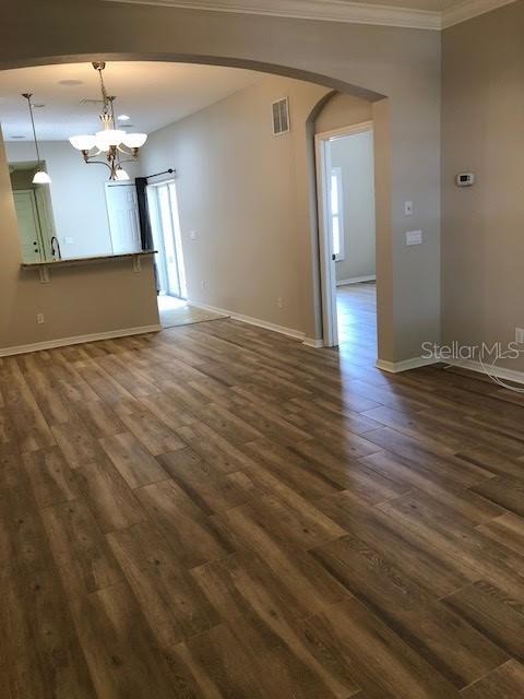 An open living area features wood-look flooring, an arched entryway, and a kitchen breakfast bar — 6344 LAKE SMITH CIRCLE, WINDERMERE, FL