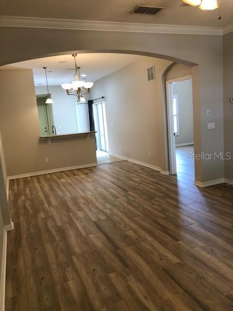 An open-concept living area features wood-look flooring, an arched entryway, and a kitchen breakfast bar — 6344 LAKE SMITH CIRCLE, WINDERMERE, FL