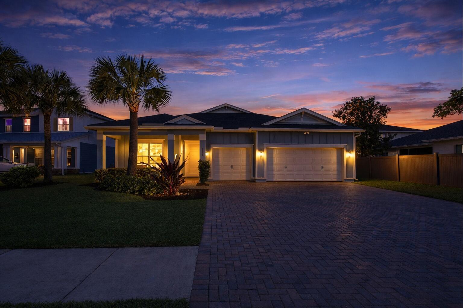 A single-story house with a paved driveway and two-car garage at twilight — 1115 Timber Reap Trail, FL 33470, FL