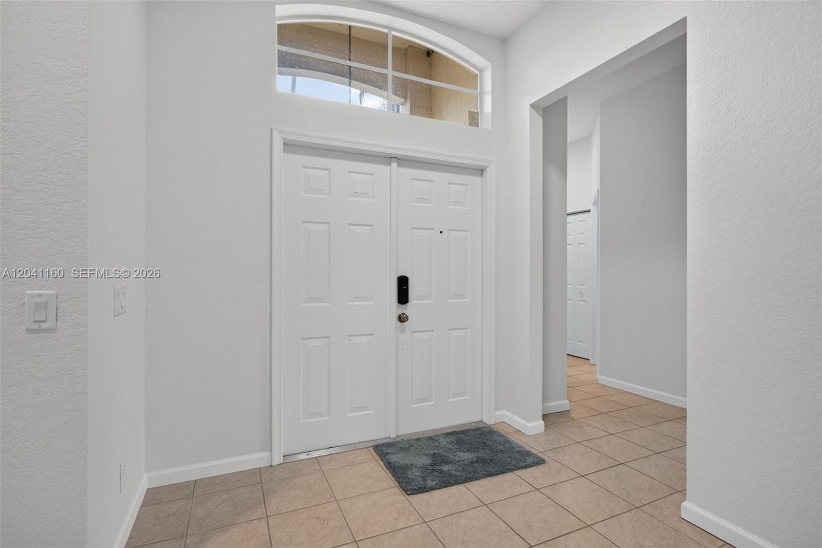 An entryway features white double doors, a transom window, and light-colored tile flooring — 786 Nandina Dr, Weston FL 33327, WESTON, FL