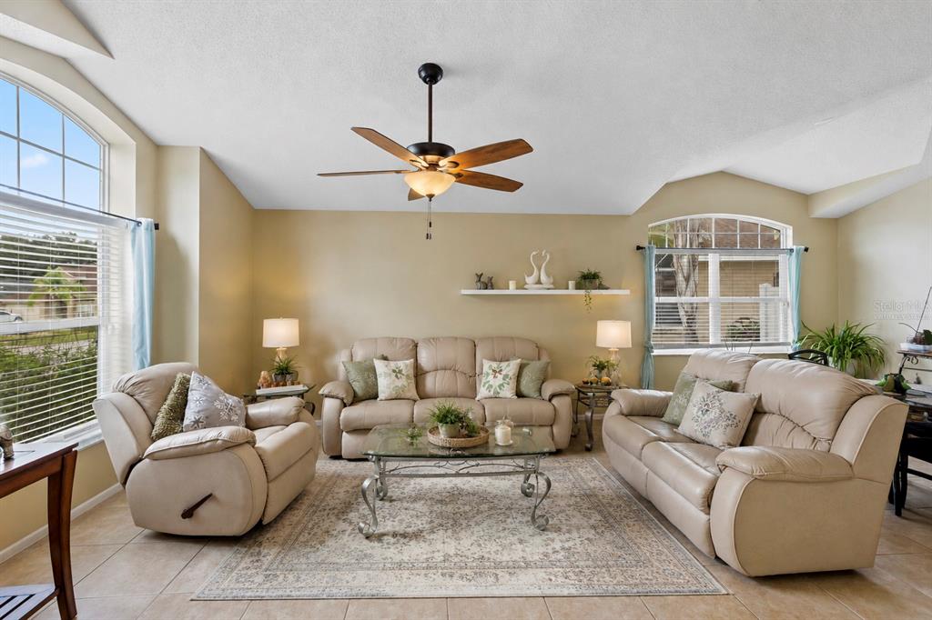 A living room features beige leather furniture, a glass coffee table, and a ceiling fan — 726 ROCHESTER LOOP, DAVENPORT, FL