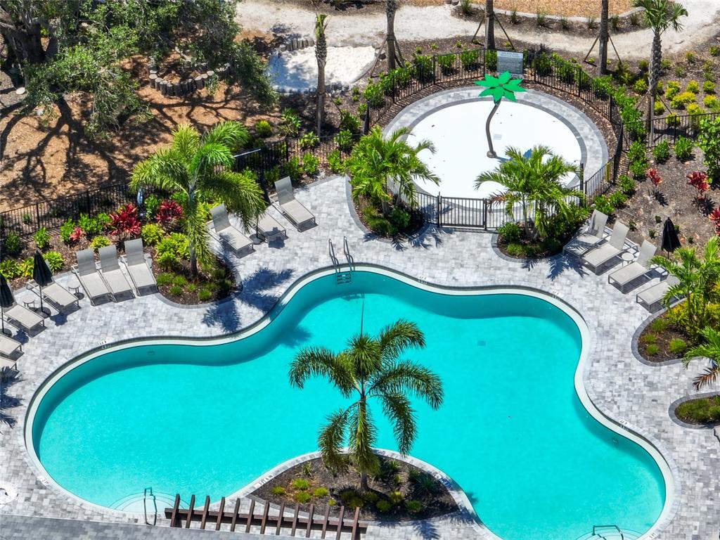 An aerial view shows a swimming pool with a palm tree and a splash pad — 5744 HAVEN TERRACE TERRACE, NOKOMIS, FL