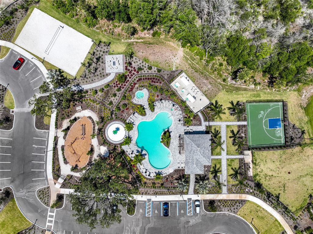 Aerial view of a community recreation area featuring a swimming pool, basketball court, and playground — 5744 HAVEN TERRACE TERRACE, NOKOMIS, FL