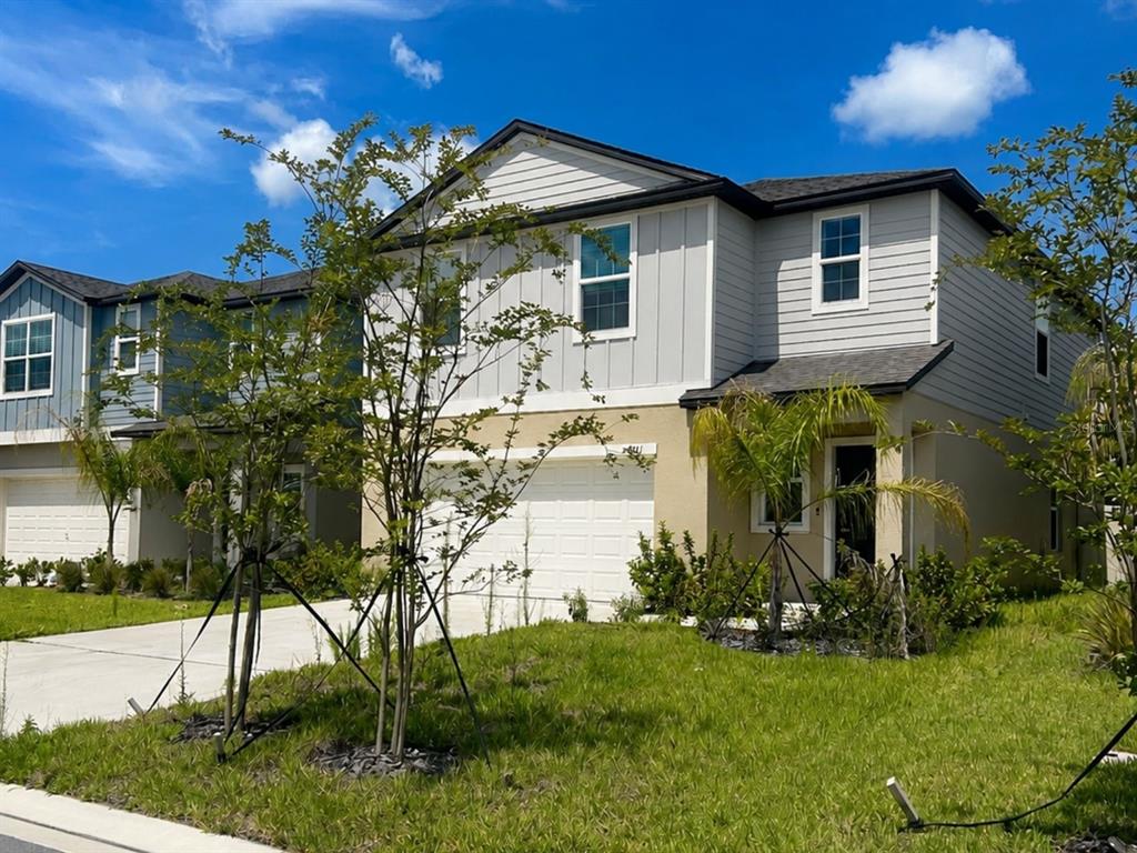 A two-story suburban house with a tan stucco lower level and gray siding above — 4011 NORTHERN KEY DRIVE, PLANT CITY, FL