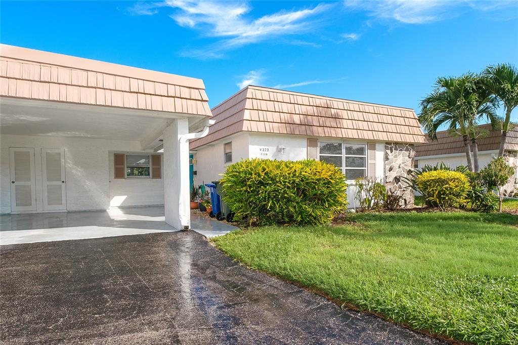 A patio with wicker furniture overlooks a canal lined with trees and grass — 2126 RIVERBLUFF PARKWAY UNIT V323, SARASOTA, FL