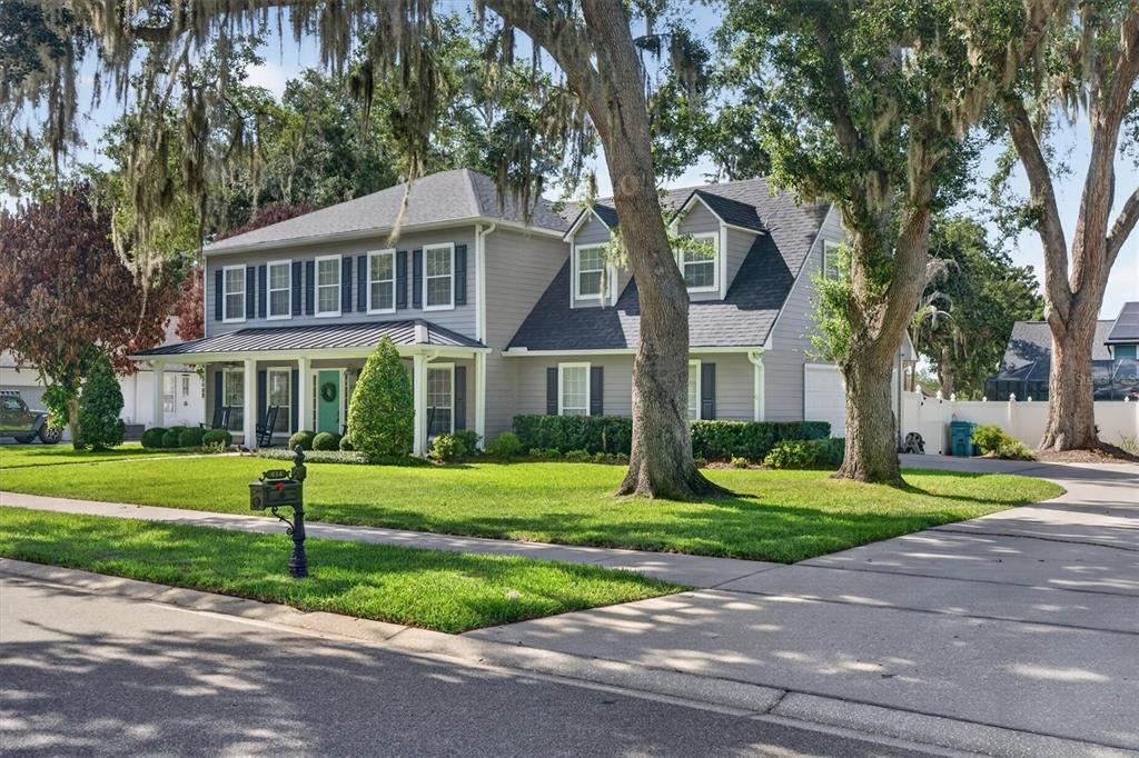 A two-story gray house with a front porch, dark shutters, and large oak trees — 434 VALLEY VIEW DRIVE, WINTER GARDEN, FL
