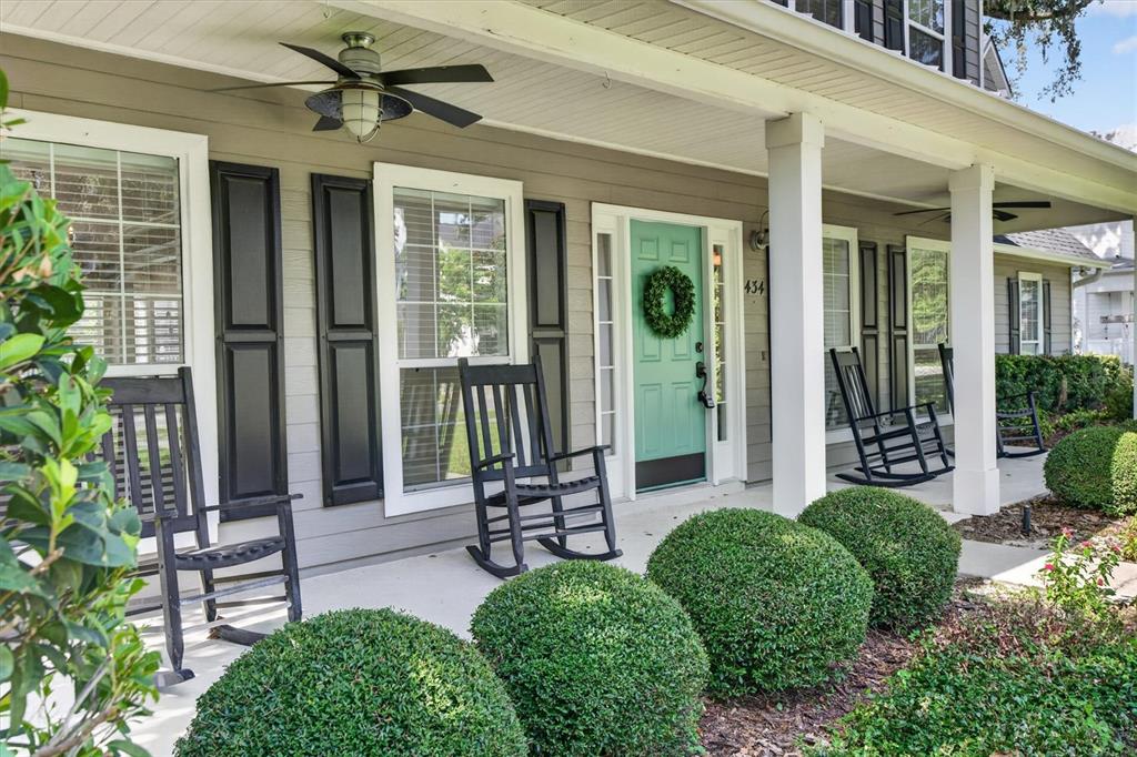 A front porch features a light green door, black shutters, and several wooden rocking chairs — 434 VALLEY VIEW DRIVE, WINTER GARDEN, FL