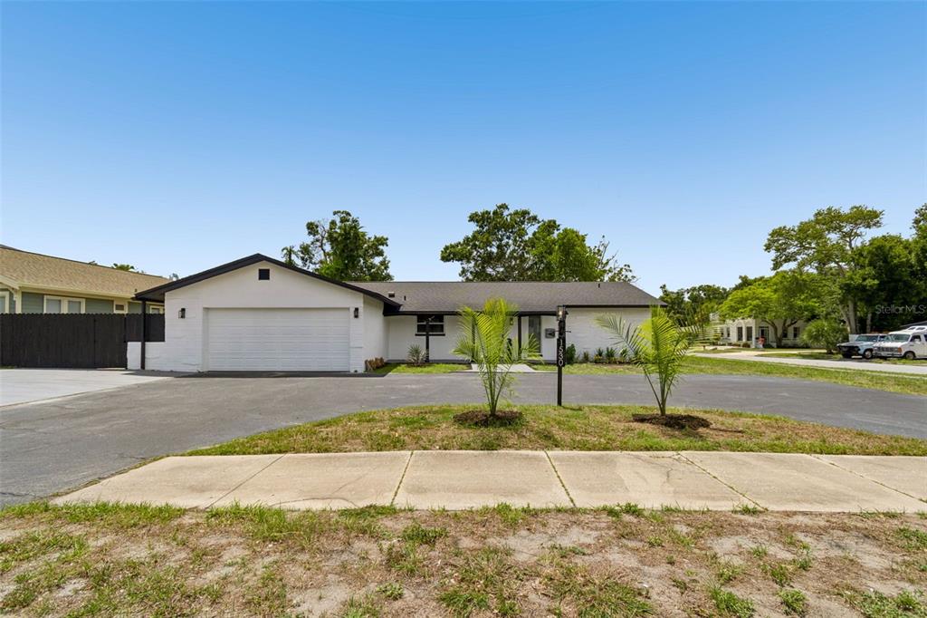 A single-story white house with a black roof and a two-car garage — 1530 49TH STREET N, ST PETERSBURG, FL