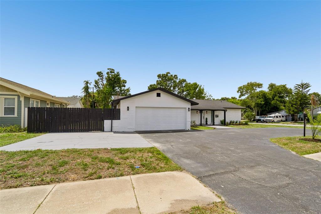 A white house with a two-car garage and a large asphalt driveway — 1530 49TH STREET N, ST PETERSBURG, FL