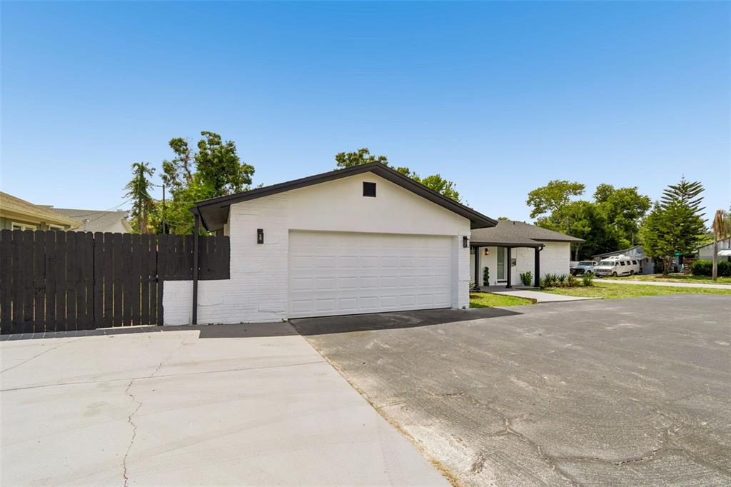 A white painted brick house features a two-car garage and a black wooden fence — 1530 49TH STREET N, ST PETERSBURG, FL