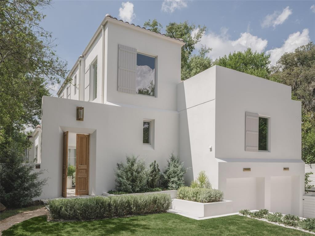 A modern two-story house with a white stucco exterior, a two-car garage, and a driveway — 1150 VIA SALERNO, WINTER PARK, FL
