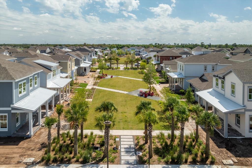 An aerial view shows a grassy park area surrounded by suburban houses with palm trees — 9527 FLOREY WAY, ORLANDO, FL