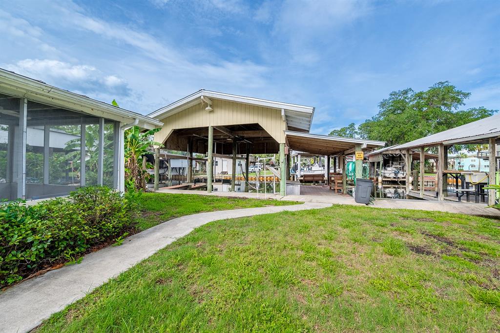 A concrete path leads to a covered boat dock and slip area behind a house — 192 SE 241ST STREET, SUWANNEE, FL