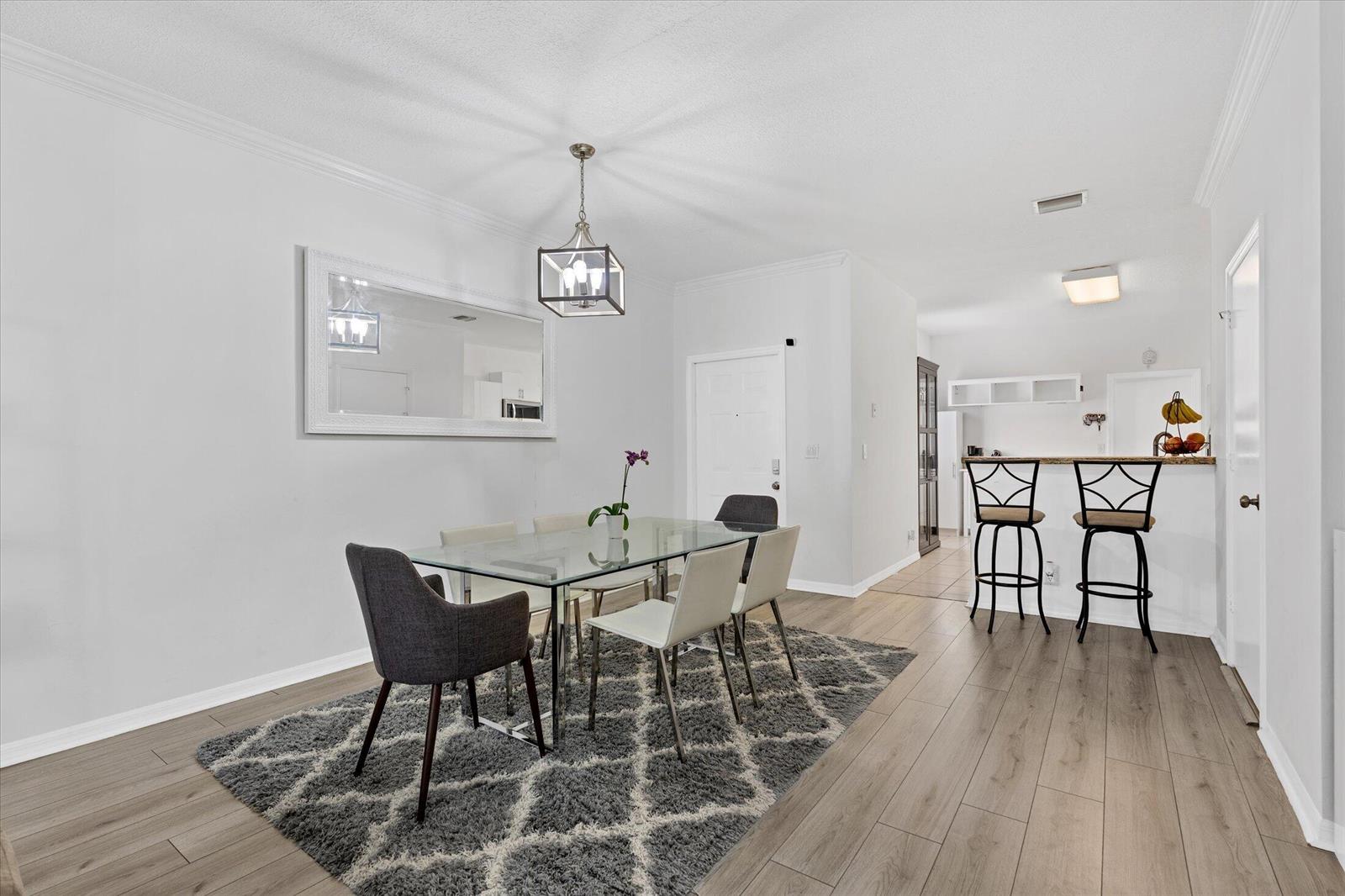 A dining area features a glass table, gray chairs, a rug, and a breakfast bar — 2264 Salerno Circle, Weston FL 33327, WESTON, FL