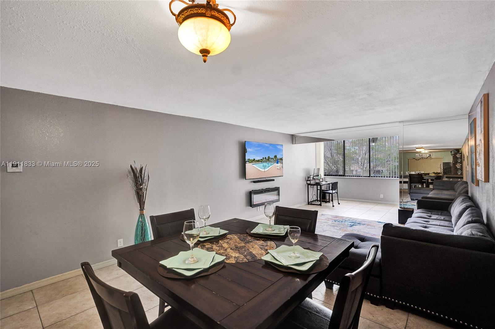 A dining area with a dark wood table sits adjacent to a living room space — 8010 Hampton Blvd # 211, North Lauderdale FL 33068, NORTH LAUDERDALE, FL