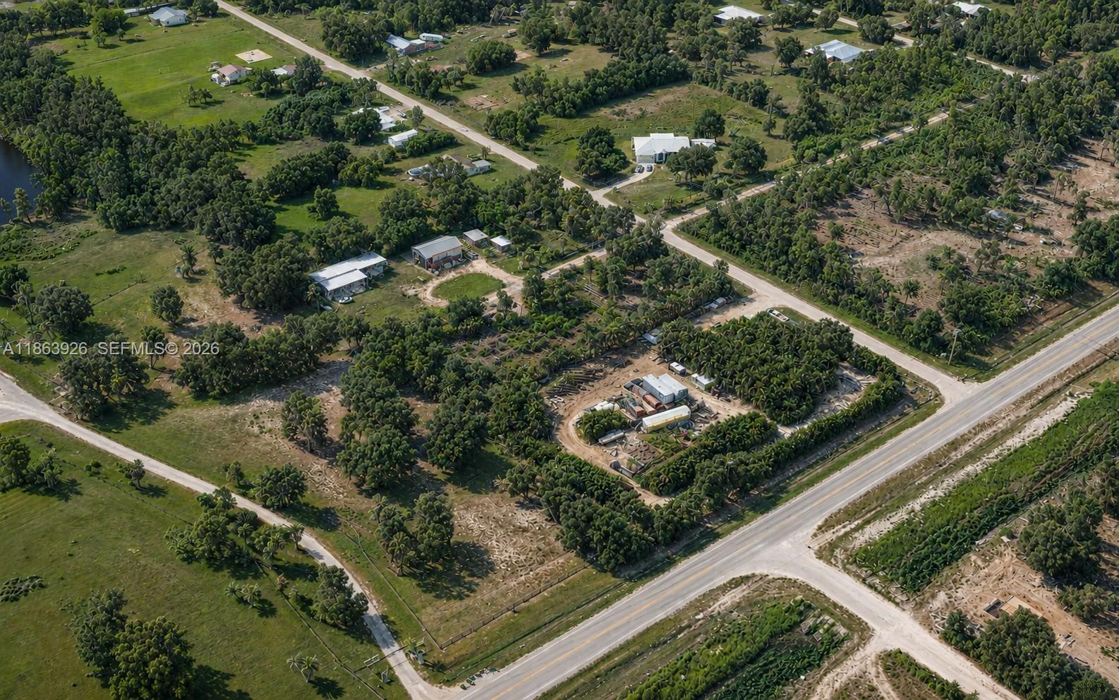 An aerial view shows rural properties with houses, outbuildings, and dense vegetation along paved roads — 29279 Hazelwood Dr, Punta Gorda FL 33982, PUNTA GORDA, FL