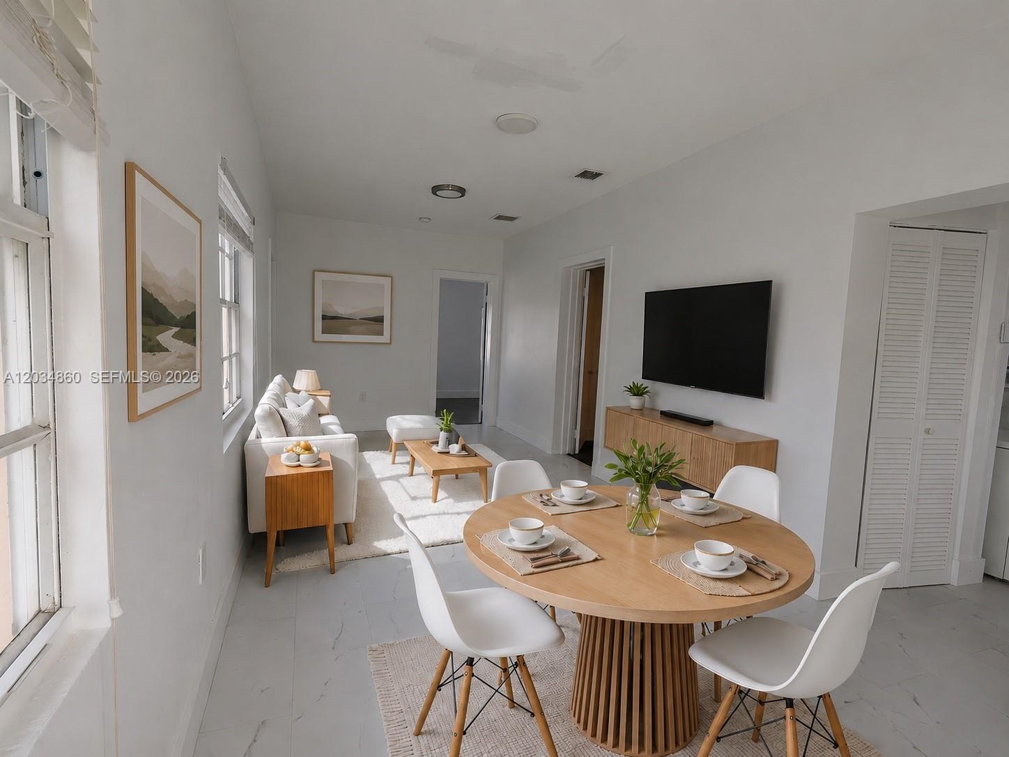 A bright open-concept living and dining area features white walls, light flooring, and modern furniture — 2272 NW 2nd St # 2, Miami FL 33125, MIAMI, FL