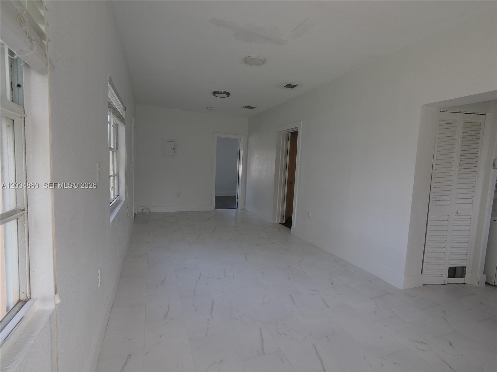 A bright, empty room features white walls, marble-patterned tile flooring, and two doorways — 2272 NW 2nd St # 2, Miami FL 33125, MIAMI, FL